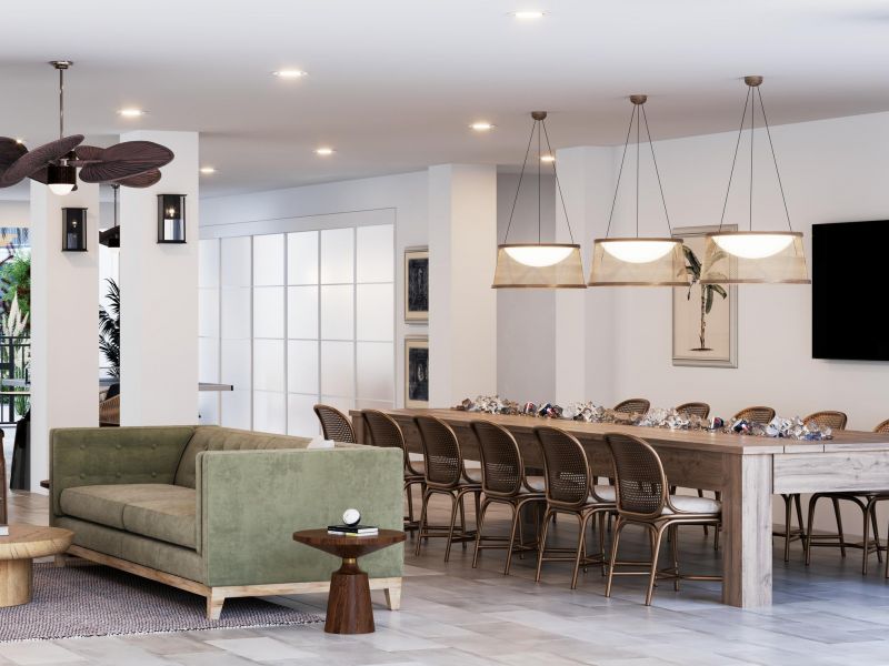 Modern open-concept living and dining area with green sofa, wood furniture, and large dining table.