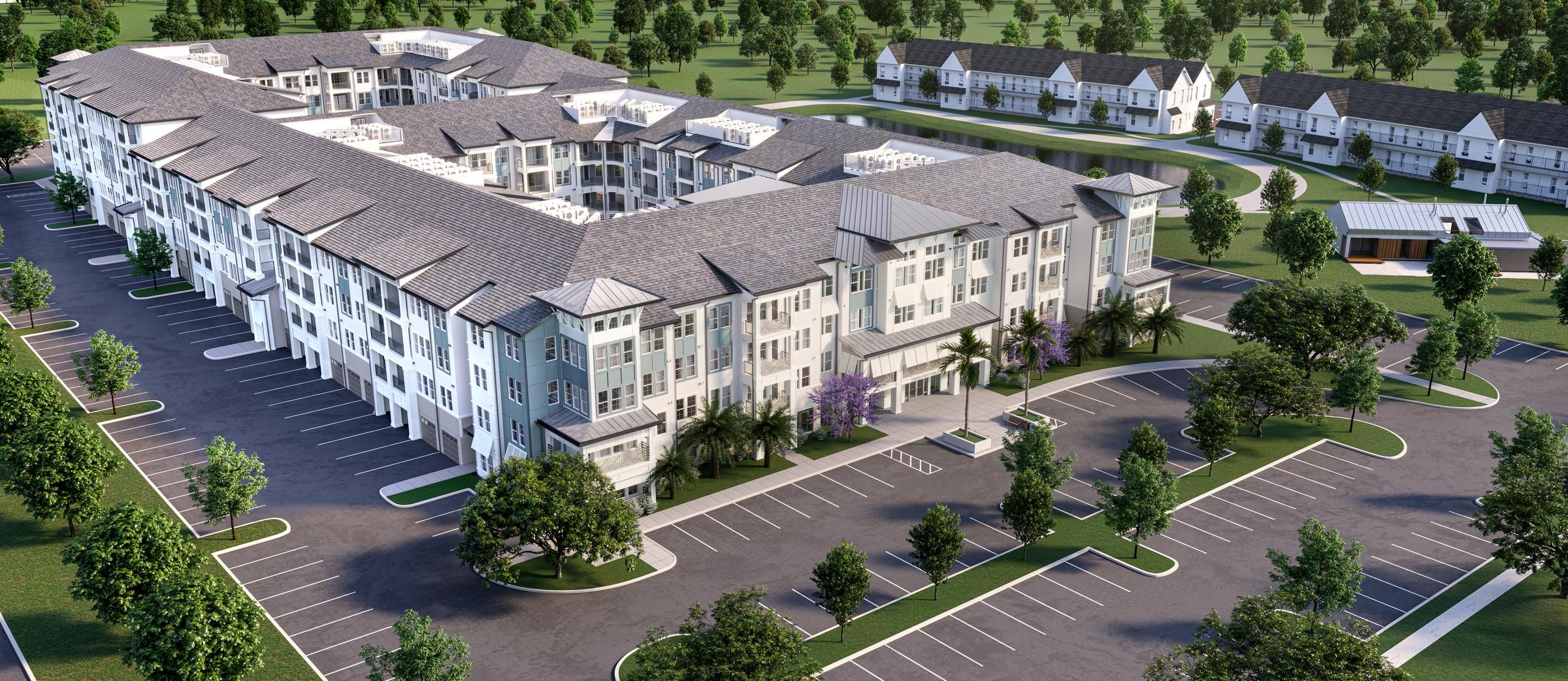 Aerial view of a large modern apartment complex with landscaped grounds and ample parking spaces.