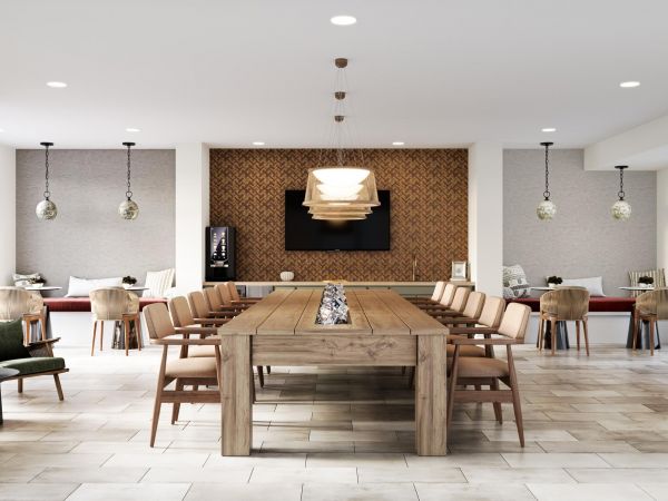 Modern dining area with a long wooden table, chairs, pendant lights, and neutral decor.