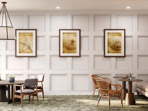 Elegant lounge with beige seating, tables, wall art, and soft lighting in a modern, airy room.