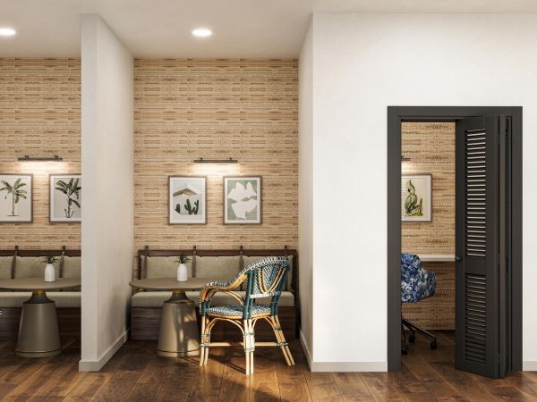 Modern office space with cozy seating nooks, wall art, and two private rooms with black louvered doors.