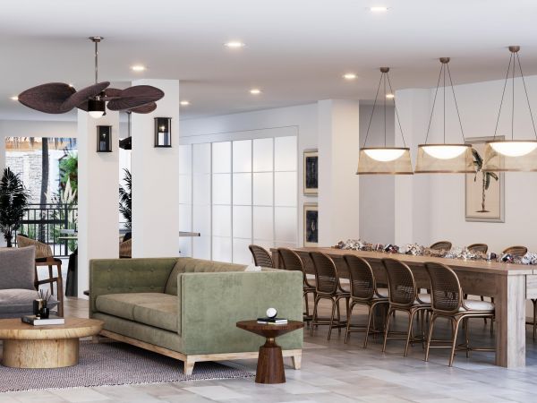 Modern open-concept living and dining area with green sofa, wood furniture, and large dining table.